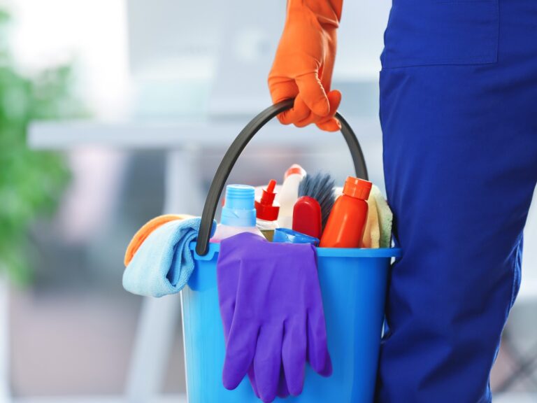 holding cleaning products and tools on bucket, close up